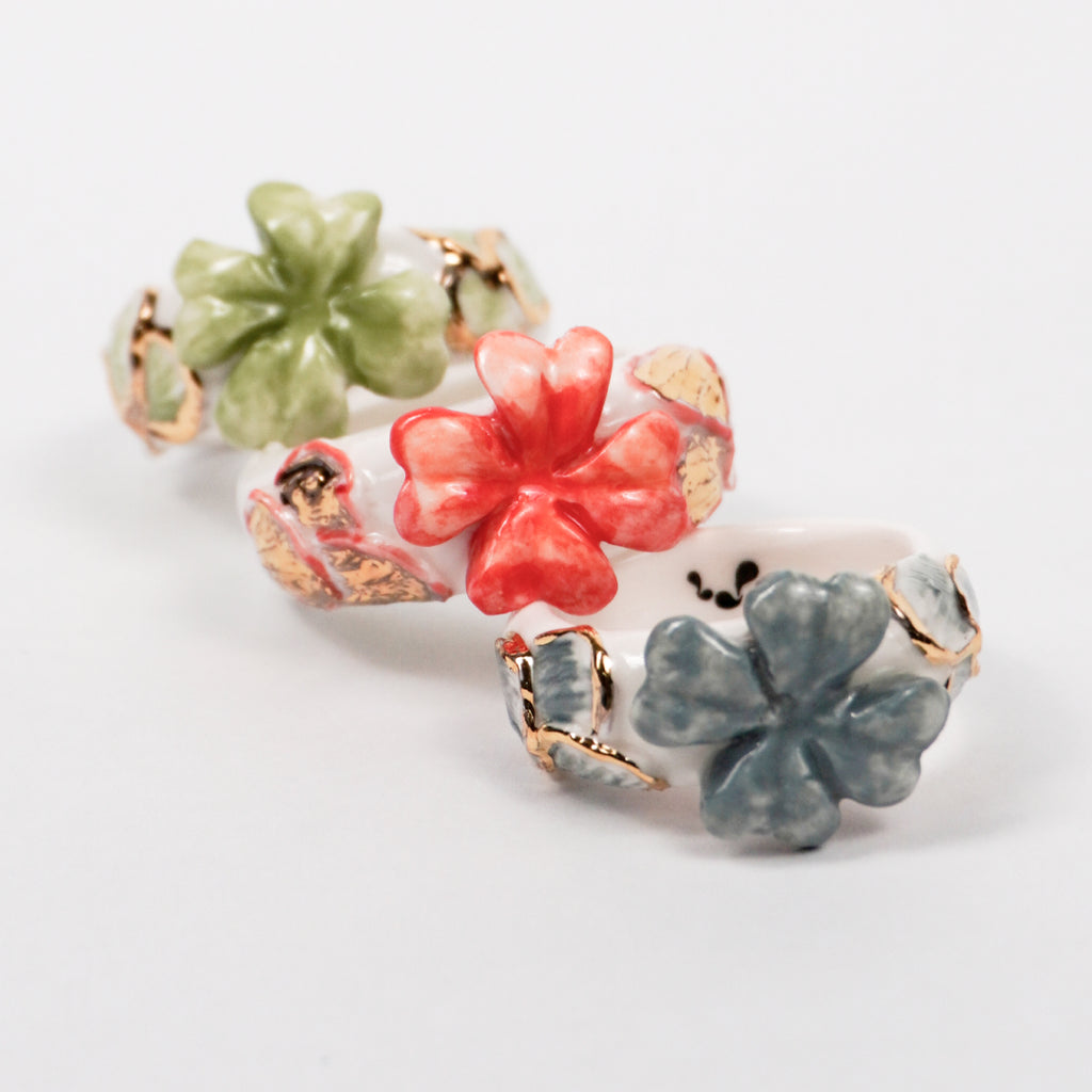 trefle-doux-d-or-edition-with-24k-gold-porcelain-ring-Leap-And-Linger-Product-Rings-by-Nomi-Bui-With-Hand-1st-Angle
